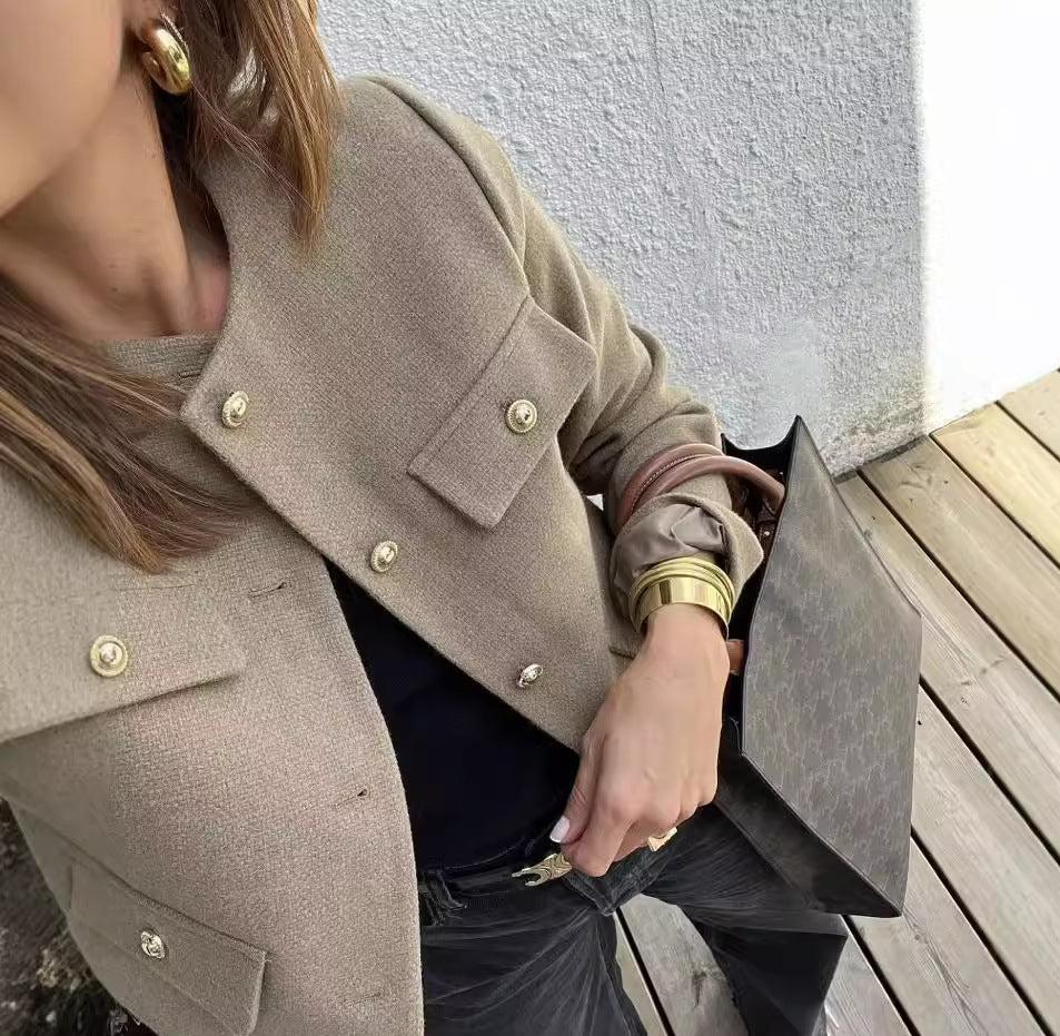 Vintage-inspired cropped jacket in a clean, round-neck design, finished with gold-tone buttons and four flap pockets. Tailored, waist-skimming silhouette in softly structured fabric adds a refined layer over dresses, denim or high-waisted trousers.