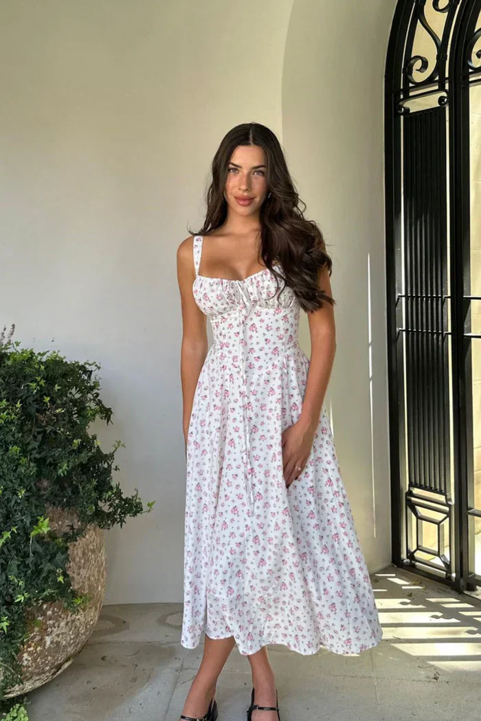 Meredith Corset Midi Dress in floral print poplin featuring a sweetheart neckline, gathered bust and structured, waist-cinching bodice. Softly flared midi skirt adds movement; romantic, versatile piece for weddings, brunches and summer parties.