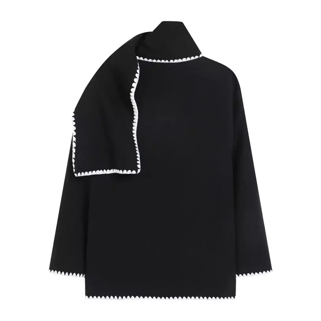 Nellie black wool-blend cape coat featuring a flowing silhouette with white contrast trim, front button fastening, practical side pockets and an attached oversized scarf collar. Warm, elegant outer layer that drapes over denim, knitwear or evening looks.