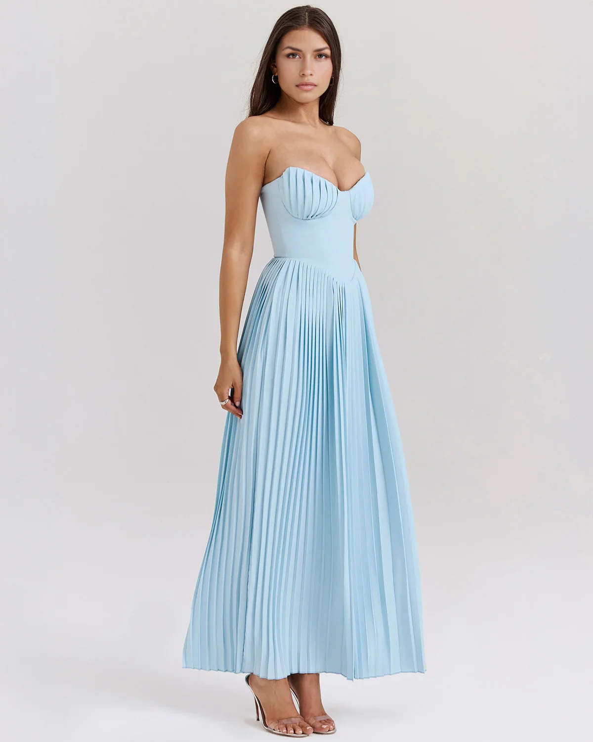 Nerina strapless pleated maxi dress with a structured bustier and seashell-pleated cups, fitted waist, and flowing pleated skirt. Soft, lightweight 100% polyester with subtle shine, ideal for resort dinners, beach weddings, and summer events.