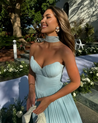 Nerina strapless pleated maxi dress with a structured bustier and seashell-pleated cups, fitted waist, and flowing pleated skirt. Soft, lightweight 100% polyester with subtle shine, ideal for resort dinners, beach weddings, and summer events.