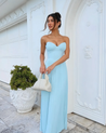 Nerina strapless pleated maxi dress with a structured bustier and seashell-pleated cups, fitted waist, and flowing pleated skirt. Soft, lightweight 100% polyester with subtle shine, ideal for resort dinners, beach weddings, and summer events.