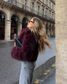 Cropped fluffy jacket in deep wine with a refined notch lapel and subtly voluminous sleeves. Plush, cosy texture and hip-skimming length create a chic layer over denim or evening dresses, adding warm, modern elegance for cooler days.