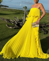 Ravello strapless pleated maxi dress featuring a layered flounce bodice, vertical knife pleats, and cascading side ruffles. Lightweight polyester drape lengthens the silhouette with elegant motion—perfect for weddings, garden parties, and evening events.