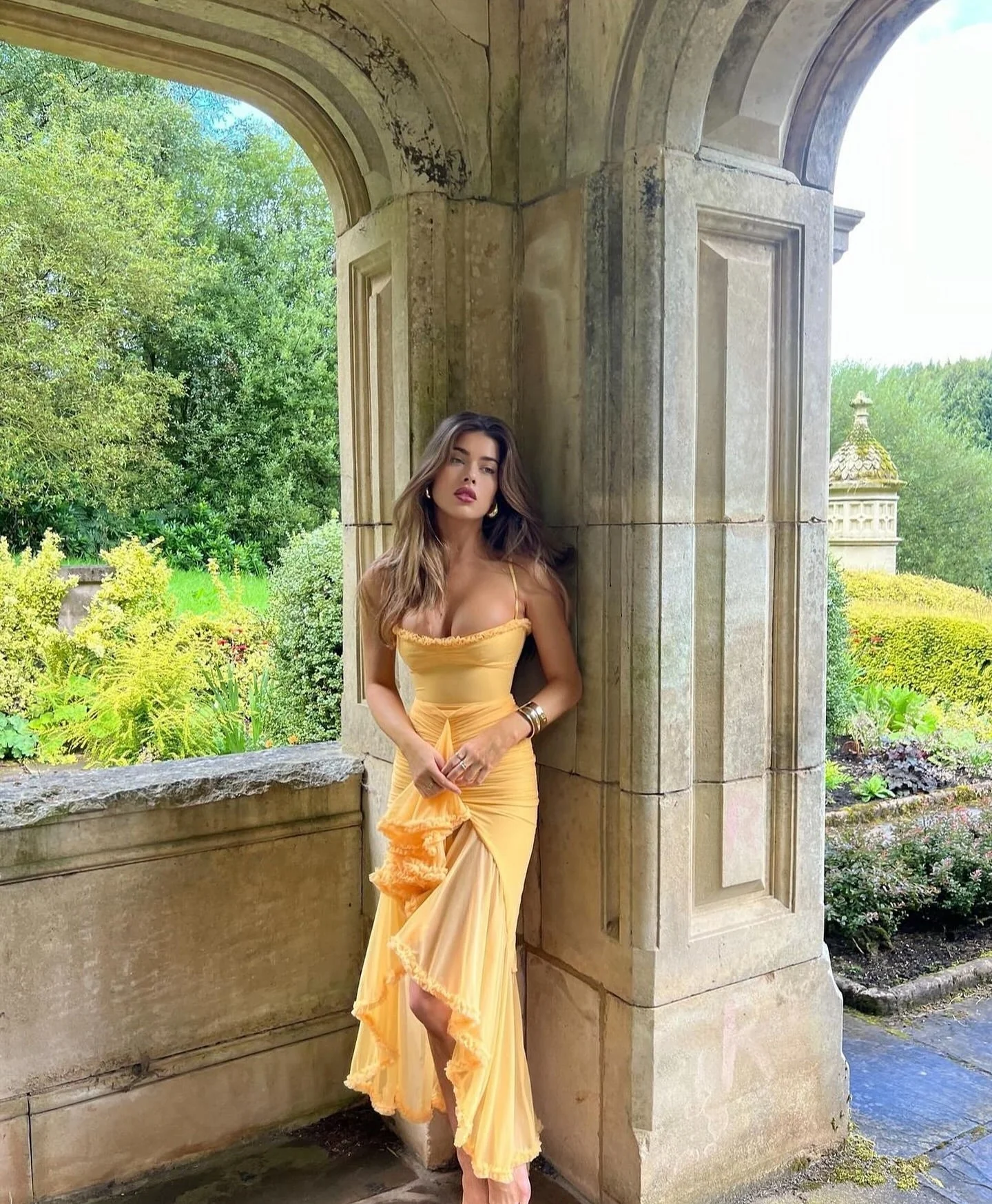 Ruffled bodycon gown with spaghetti straps in lightweight polyester blend, featuring ruched waist, cascading ruffle hem, and high slit. Elegant neckline and sleek silhouette ideal for formal events and cocktail evenings.