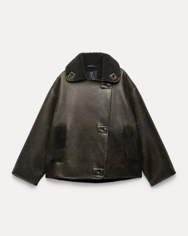 Women’s outerwear jacket in synthetic leather with plush shearling-effect lining, high stand collar and asymmetric button closure. Relaxed silhouette with lined hand pockets for cozy warmth and effortless layering from day to night.