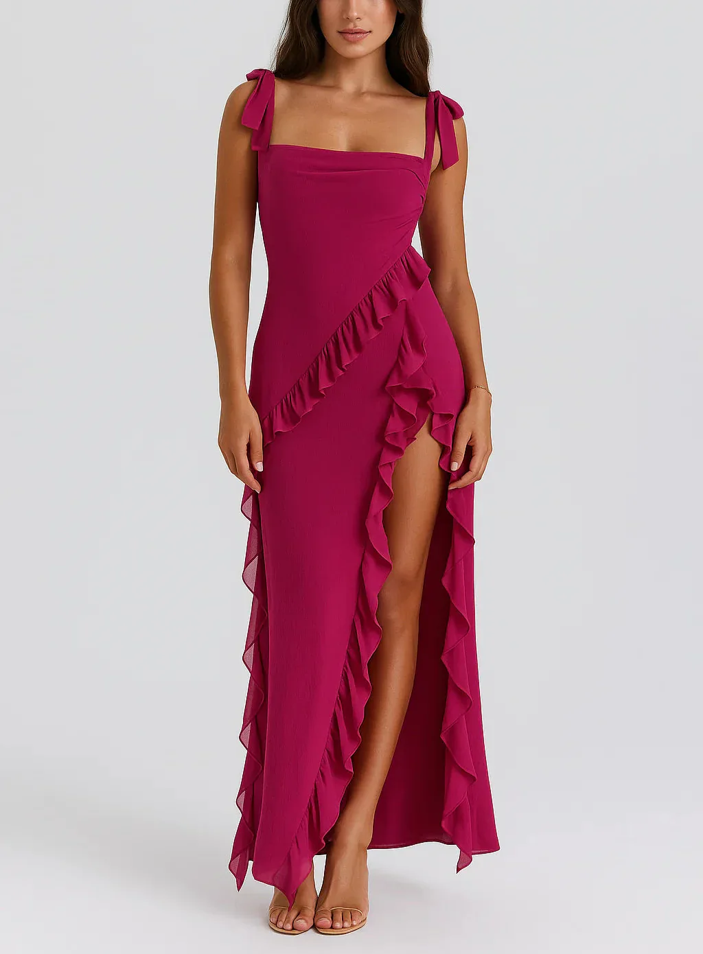 Tabitha Stylish Ruffle Dress in a maxi length featuring a square neckline, adjustable bow straps and a thigh-high side slit framed by cascading diagonal ruffles. Lightweight fabric skims the body, flattering the waist for chic day-to-night occasions.